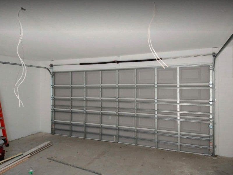 Newly installed garage door with metal frame and empty interior space.