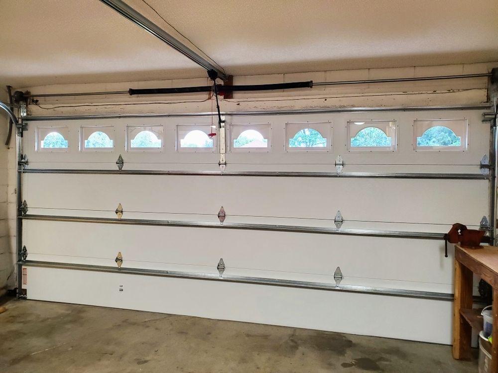 Newly installed modern steel garage door on a residential home exterior.